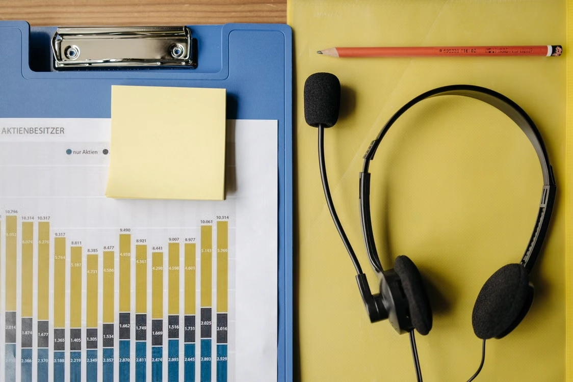 Headset next to a clipboard with charts
