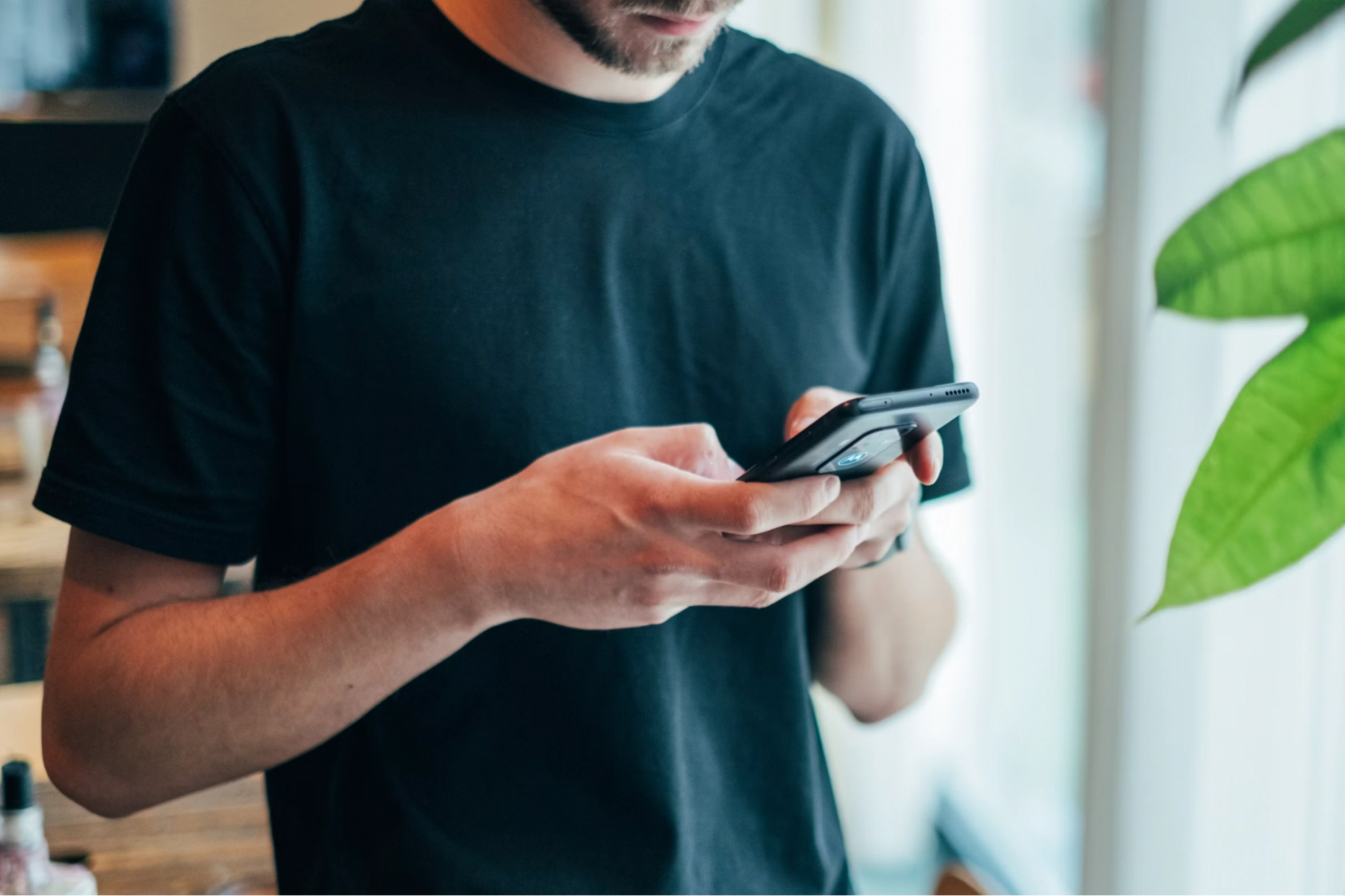 man in black t-shirt using a smartphone