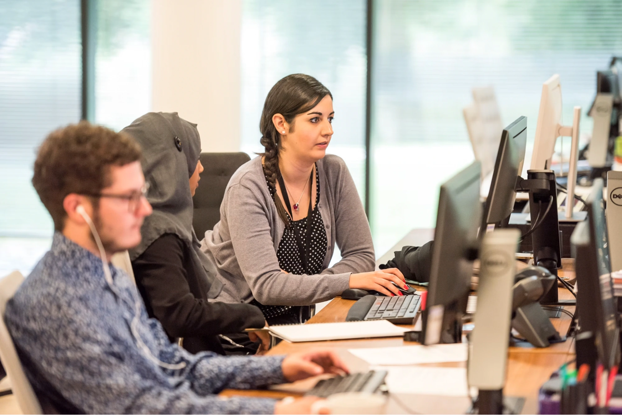 Office workers sitting in a row working at computer desks