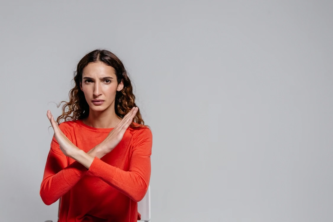 Woman making a stop gesture crossing her arms