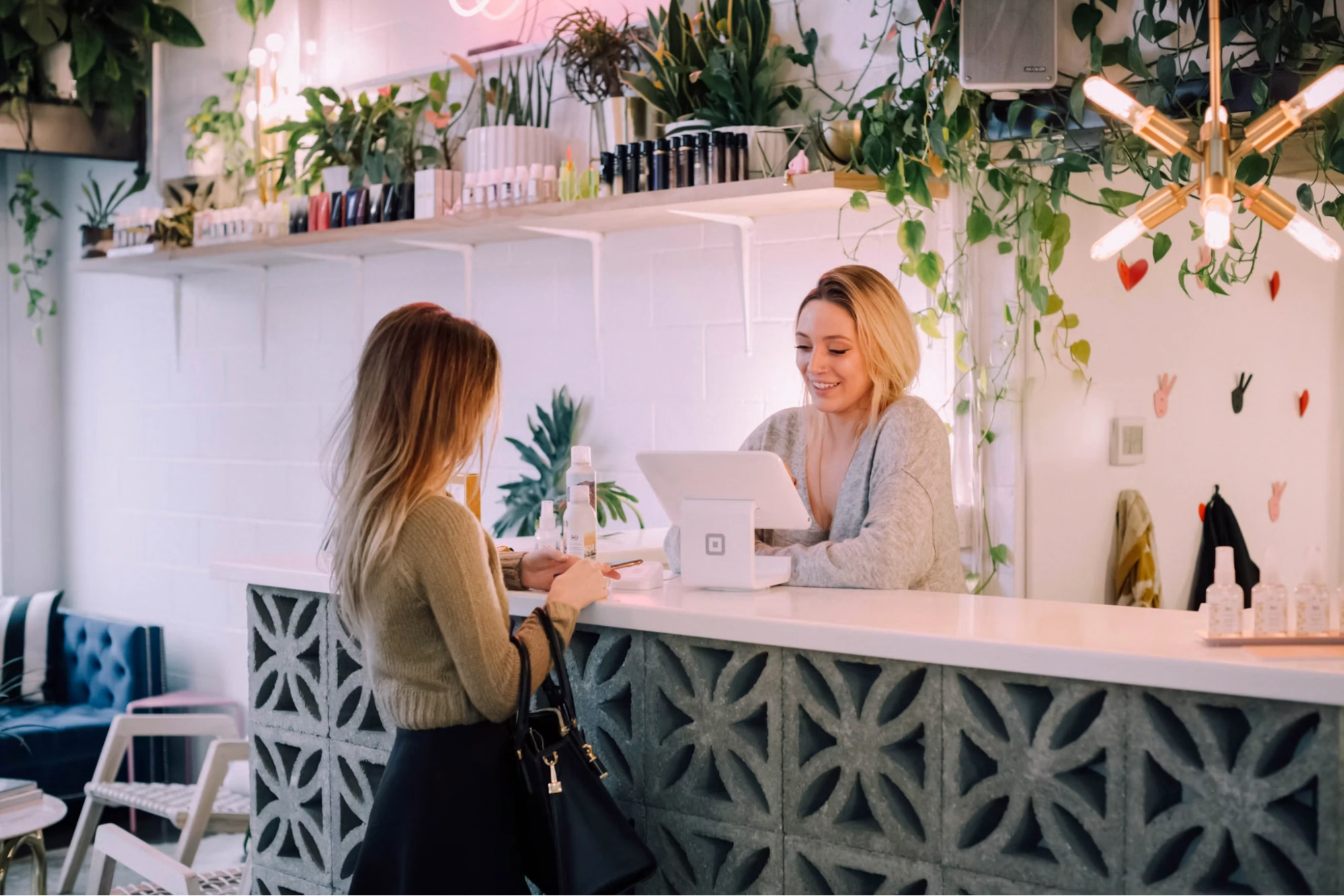woman paying at a salon checkout counter