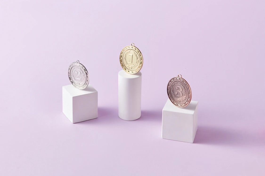 gold silver and bronze medals on white display pedestals