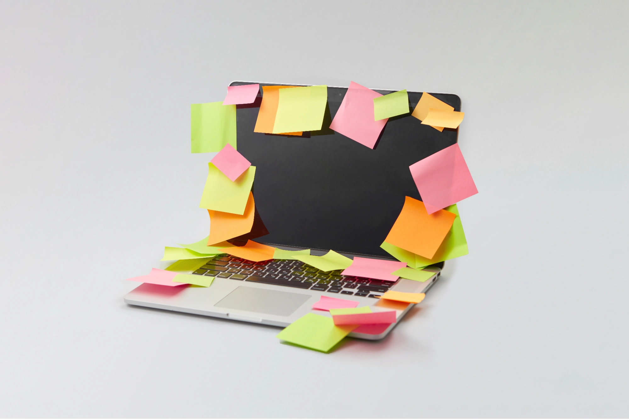 Laptop covered in colorful sticky notes on screen and keyboard